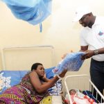 M. Sorho Moussa, Responsable de l’usine de production de Awa remettant un sac de bébé à une nouvelle maman.