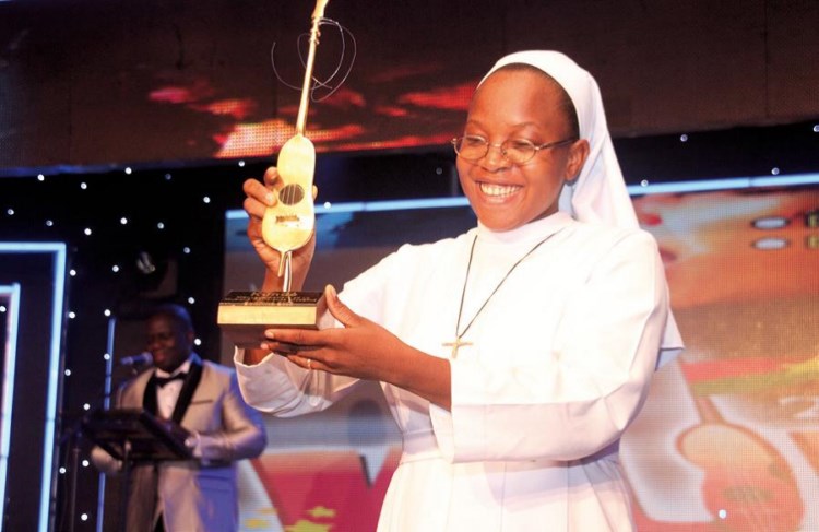 Soeur Anne-Marie Kabré brandit son trophée de la meilleure musique religieuse.