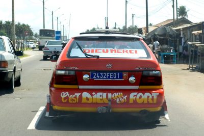 Taxi cabs are painted in orange, and leave space for hand-painted messages, as here they claim 'It's God who is strong' and 'Thanks God' (in French), in Abidjan, Ivory Coast, on November 4, 2010. Photo by Lucas Schifres/Pictobank